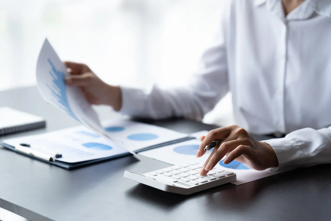 Reviewing business accounts with a calculator and financial reports